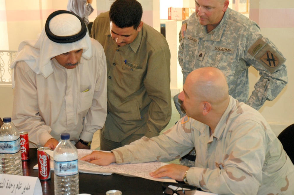 Local Iraqi leaders review a map