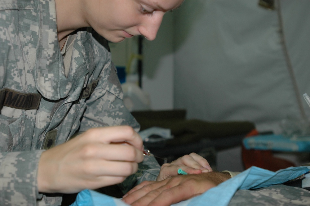 Spc. Marlene Raymond administers an IV