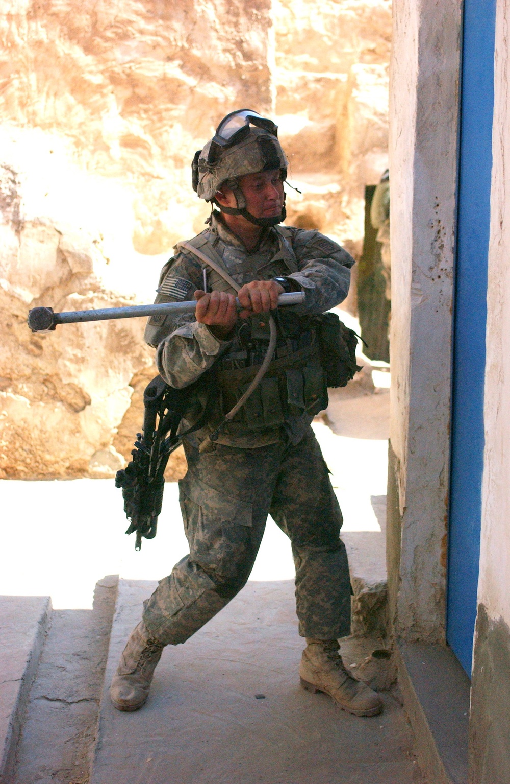 Spc. Kenneth S. Freeman uses a sledge hammer to open a door