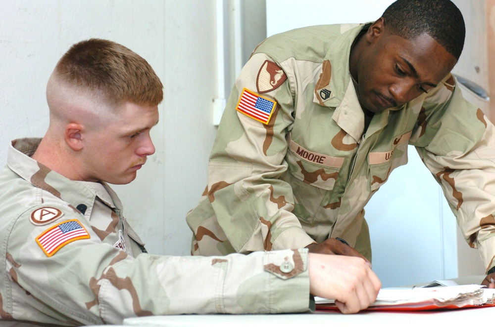 SSG Moore goes over study materiel with SPC Woodbury