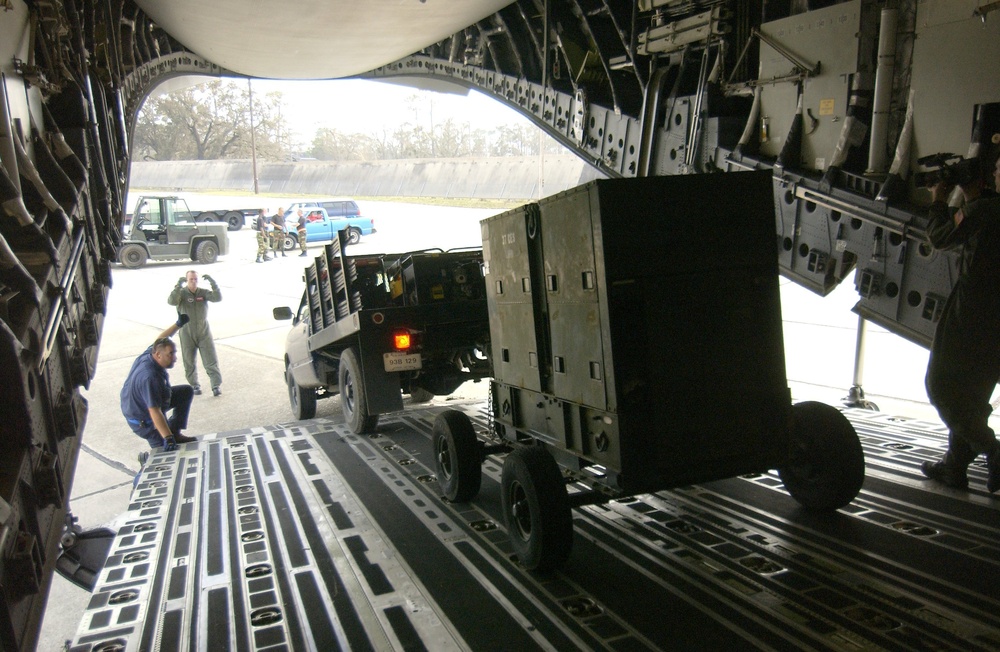 U.S. Air Force members download a generator from a C-17