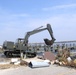 A track hoe is used to remove debris from Hurricane Katrina near the marina