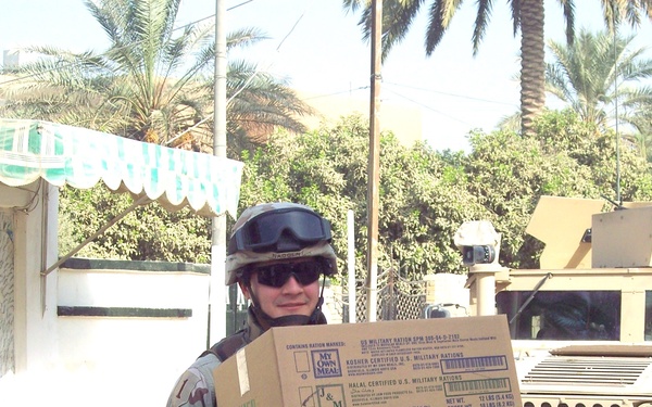 Spc.  Nadolny delivers military ration meals to the Al-Aman Primary School