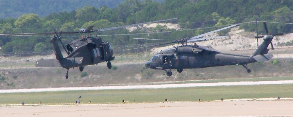 Two UH-60 Blackhawk helicopters prepare for take off