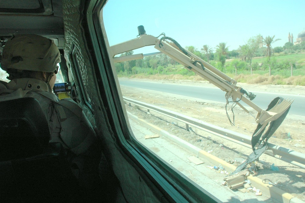 Sgt. Willy Sobczak uses a remote control to maneuver the retractable arm on