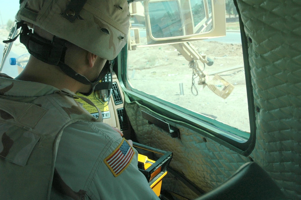 Sgt. Willy Sobczak uses a remote control to maneuver the retractable arm on