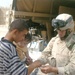 Pfc. Oscar Grado provides a couple of Iraqi kids with medical items