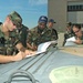 Service members inspect, weigh and file paperwork for a humvee to be transp