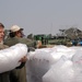 Soldiers and civilians load ice onto pallettes