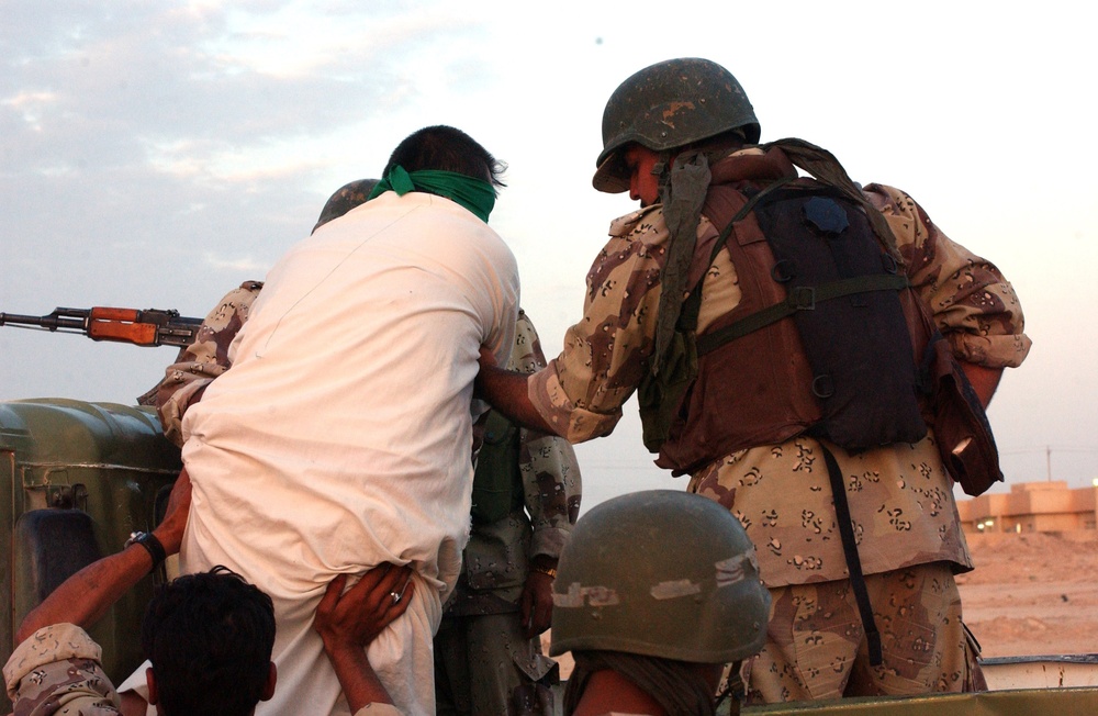 Iraqi army Soldiers load prisoners onto a truck