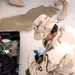Spc. Patricia Peterson looks in a camel bag for any prohibited items.