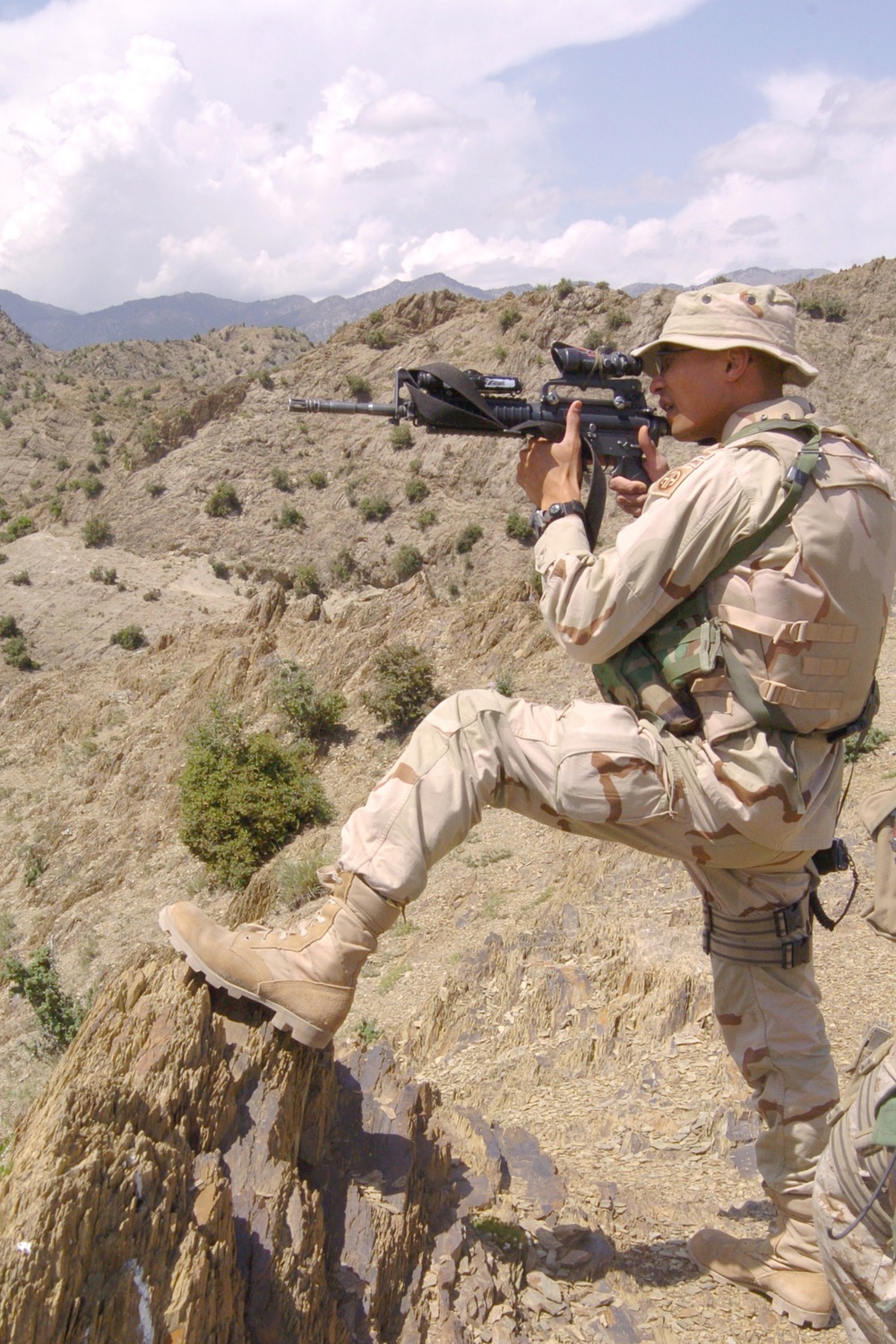 Capt. Edward Hollis uses the scope on an M4 carbine to scan a distant ridge