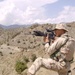 Capt. Edward Hollis uses the scope on an M4 carbine to scan a distant ridge