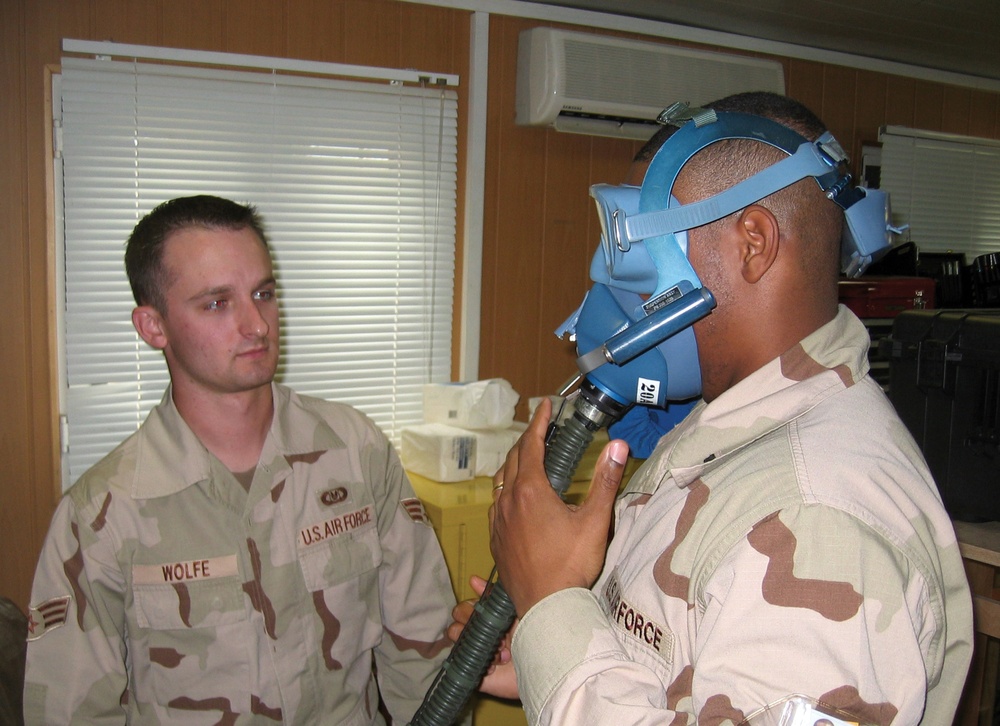 Senior Airman Rob Wolfe instructs 1st Lt. John Hurley how to wear a quick-d