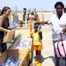 Sgt. Lea Carpenter hands MREs and water to a New Orleans family