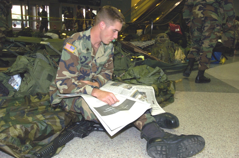 Spc. Nicolas Eigenberger reads the morning paper at his te