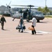 A Paratrooper helps evacuees load  onto a UH-60 Blackhawk
