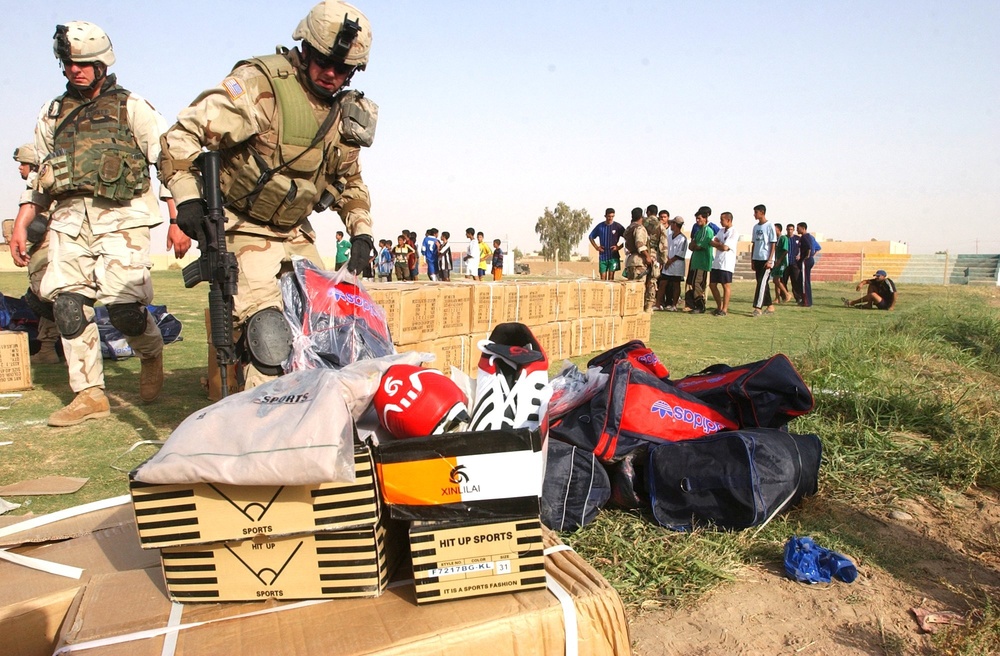 Soldiers organize soccer uniforms and equipment on a soccer field