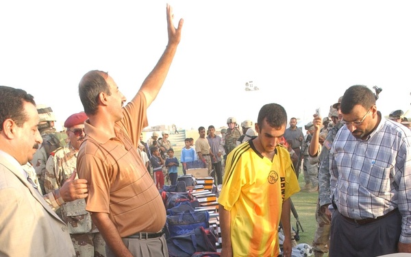 Iraqi policemen equally distribute soccer equipment for 25 teams in the Tir