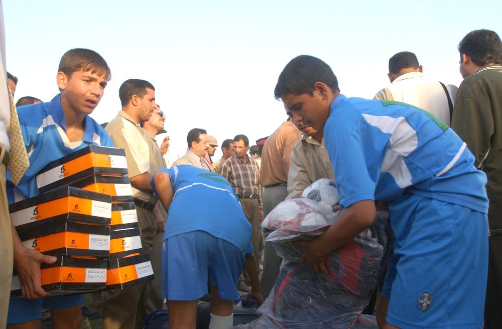 Iraqi boys collect soccer (football) balls and soccer shoes for their team