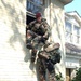 Spc. Chase Carman climbs out of the second-floor window of a flo