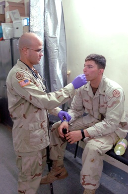 Sgt. Kevin Pantoja checks a Soldiers temperature