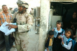 Sgt. Shaun Mance hands out T-shirts to Zafarania children during Operation