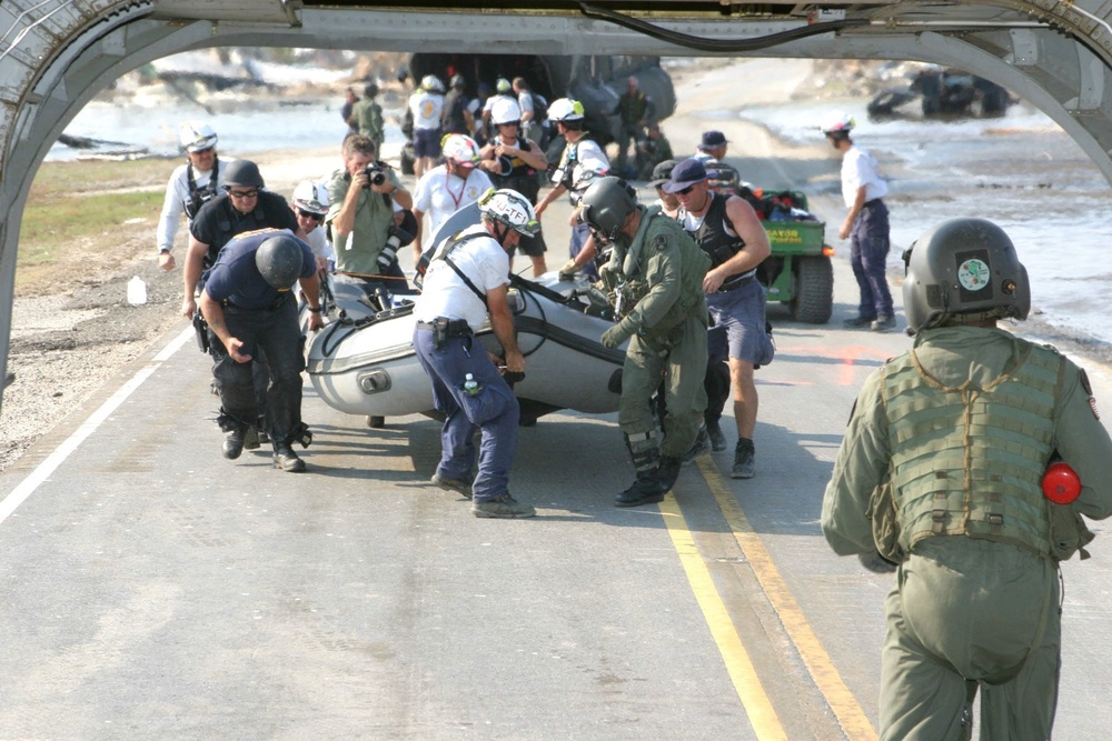 Staff Sgt. Brian Ogle Helps Members of a FEMA Search Team Carry Their Boat