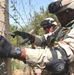 Staff Sgt. Stewart cuts a barbed-wire fence to gain access to a treeline be