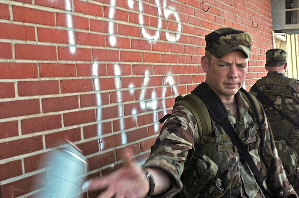 Sgt. Michael White tosses a can of spray paint back to another Soldier afte