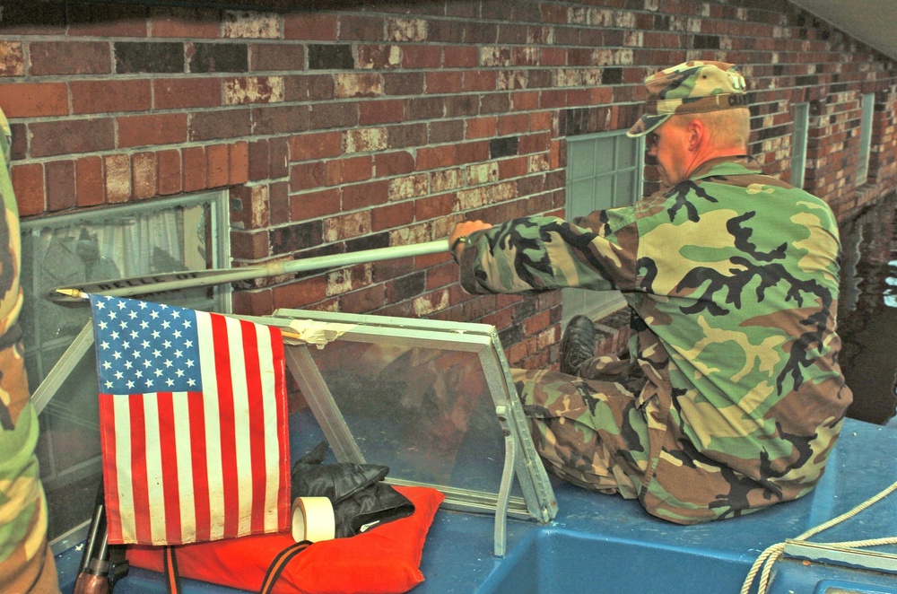 Sgt. Scott Crawford breaks through the window of a house during search and