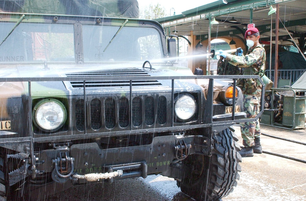 Spc. Adolfo Cosino sprays down a Humvee