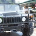 Spc. Adolfo Cosino sprays down a Humvee