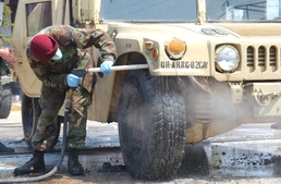 Pvt. Jerel Ridgley sprays down a humvee