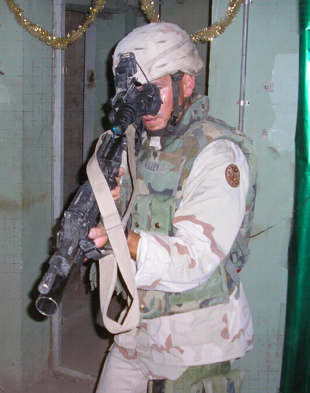 A Soldier enters a building wearing night vision goggles during urban operations