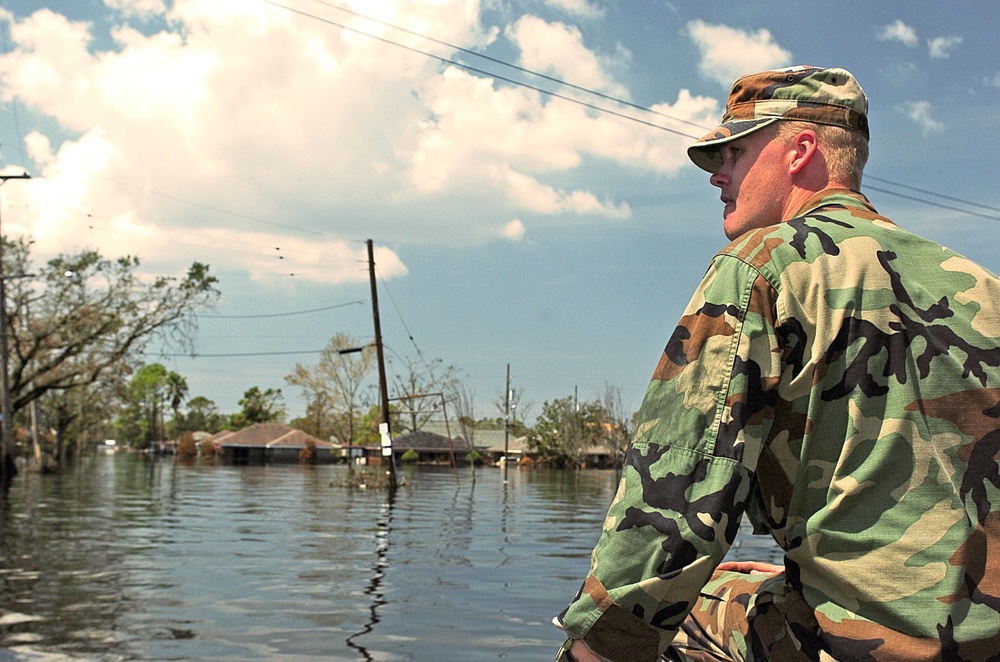 Sgt. Scott Crawford rides at the front of a boat keeping an eye out for obs