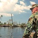 Sgt. Scott Crawford rides at the front of a boat keeping an eye out for obs