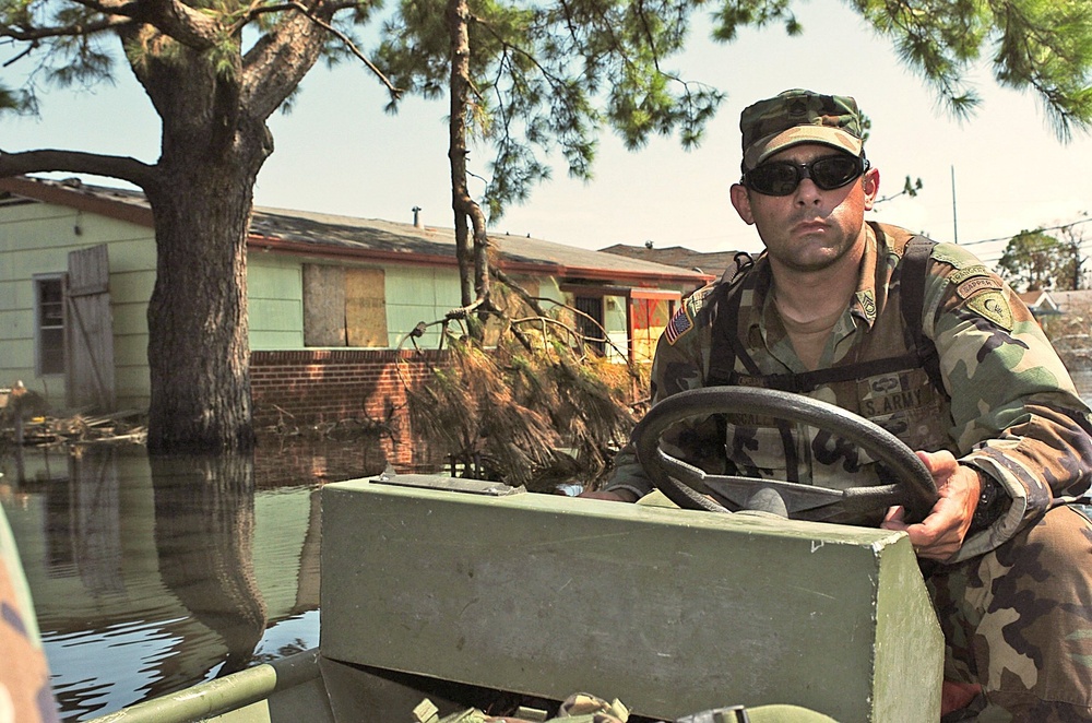 Sgt. 1st Class James Scally guides a boat along a flooded street
