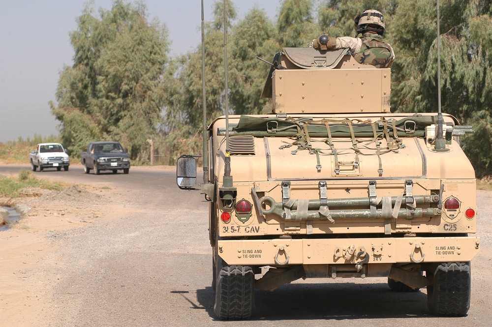 A Cavalry Scout guards vehciles from closing on a vehicle being searched