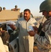 An Iraqi soldier checks an Iraqi man's identification card