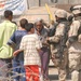 Soldiers talk with Iraqis while patrolling the city of Balad