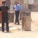 Iraqi policemen pour out plastic containers of fuel