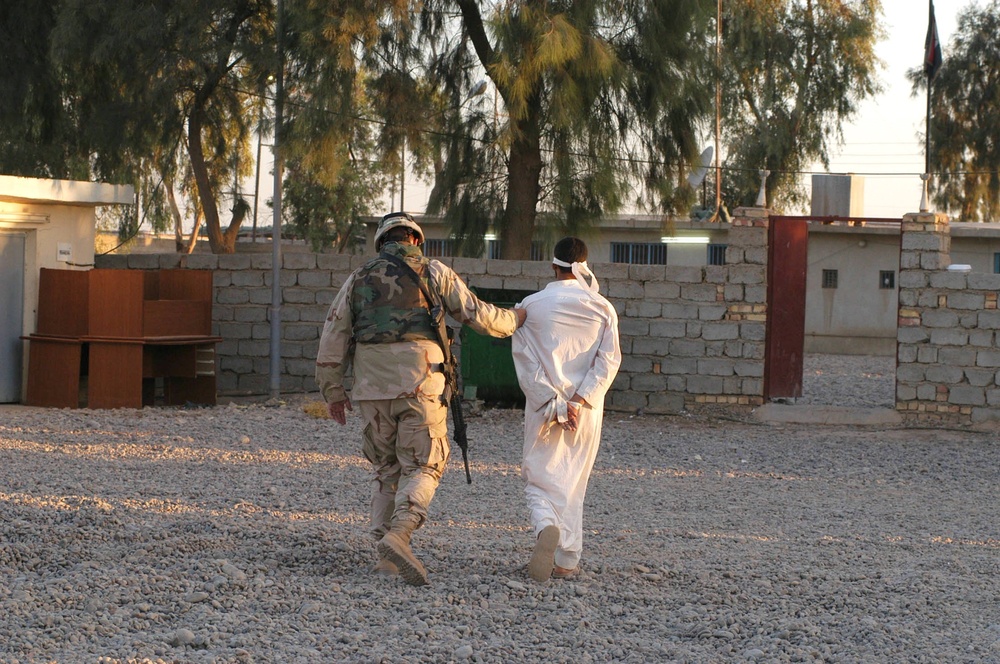 Sgt. 1st Class Perez escorts a detainee