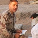 An Iraqi soldier talks to a detainee