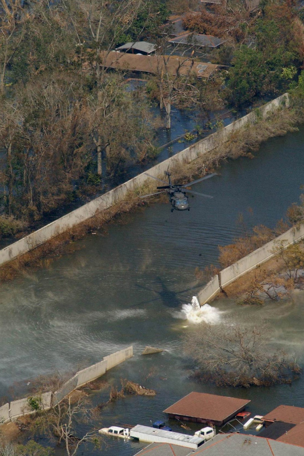 A UH 60 Blackhawk drops a sandbag into a hole in the levee