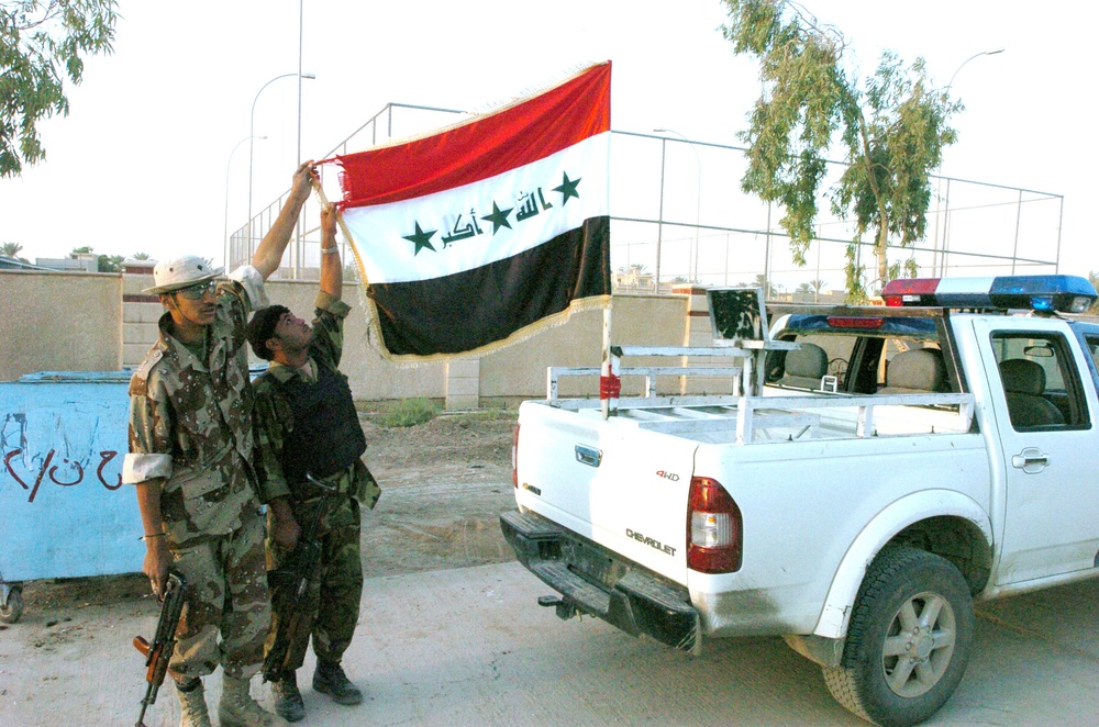 Public Order Brigade troopers proudly display the Iraqi flag