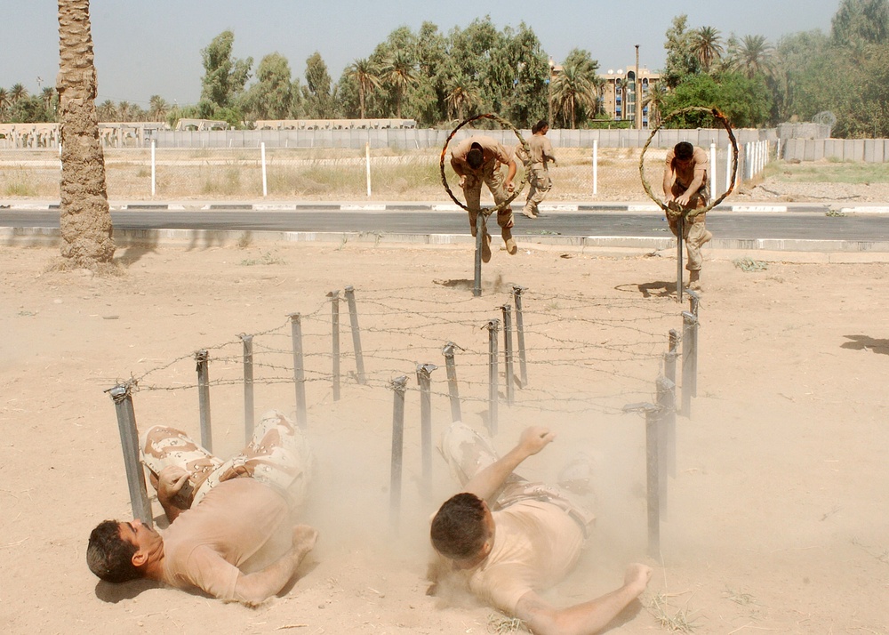 Iraqi Soldiers jump through rings of fire and crawled under barbed wire