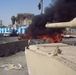 A vehicle burns outside one of the entrances of the International Zone