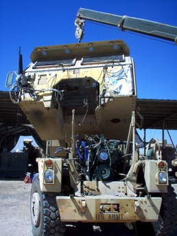 Mechanics lift off the cab of a Heavy Equipment Transporter Tractor