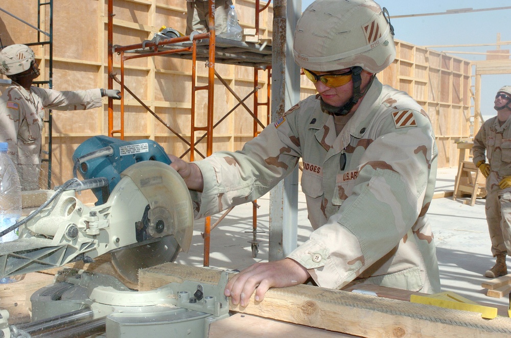 Spc. Matthew Bridges cuts a piece of wood